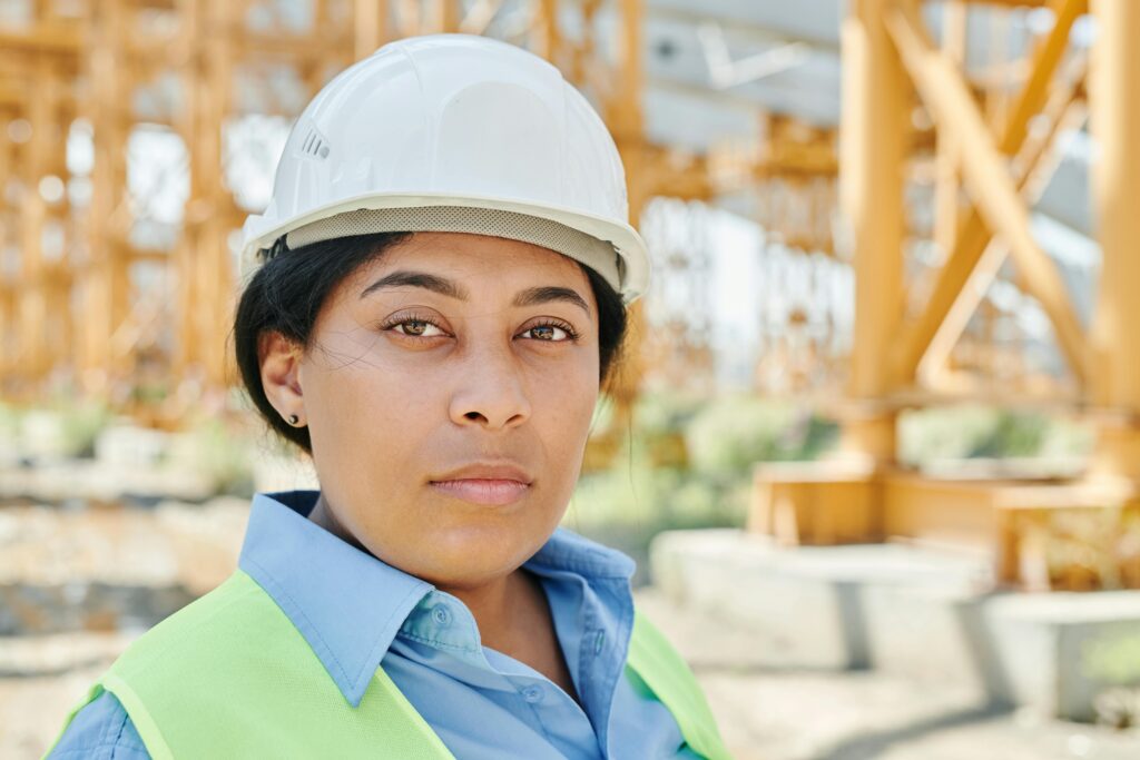 Portrait of a female engineer wearing a hard hat and safety vest on a construction site.