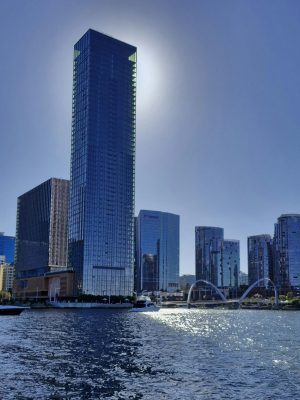 Stunning view of Perth skyline with sunlit skyscrapers reflecting on the Swan River.