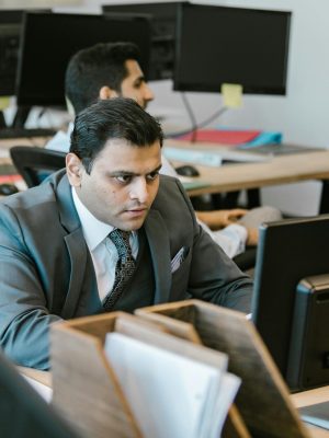 A dedicated businessman in a suit concentrating on work at a modern office desk.
